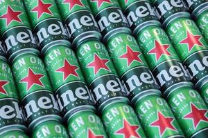 KHARKOV, UKRAINE - JULY 31, 2021 Green tin cans of Heineken lager beer produced by the Dutch brewing company Heineken N.V. photo
