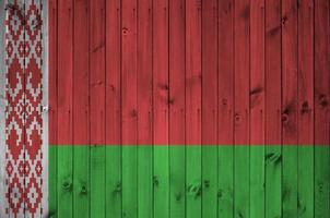 Belarus flag depicted in bright paint colors on old wooden wall. Textured banner on rough background photo
