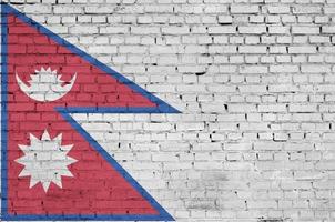 Nepal flag is painted onto an old brick wall photo