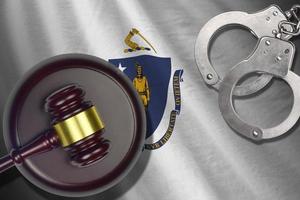 Massachusetts US state flag with judge mallet and handcuffs in dark room. Concept of criminal and punishment photo