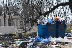 el bote de basura está lleno de basura y desechos. retiro intempestivo de basura en zonas pobladas foto