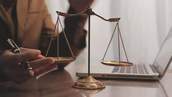 Business and lawyers discussing contract papers with brass scale on desk in office. Law, legal services, advice, justice and law concept video