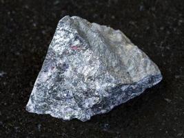 rough antimonite stone on dark background photo