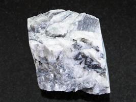rough magnesite stone on dark background photo