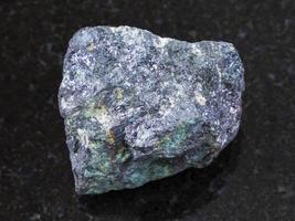 raw bornite stone on dark background photo