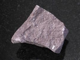 rough Aleurolite stone on dark background photo