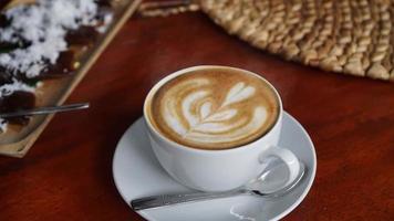 Cappuccino coffee with a very creamy and steamed milk design in the center of the cup video