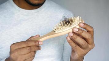 Man holds a dirty hair brush, hair loss video