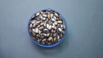 top view of melon seeds in a bowl on black background video