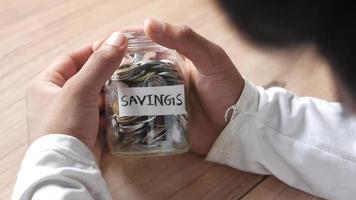 Man holds a savings jar video