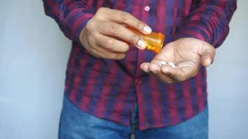 Man taking pills out of orange container video