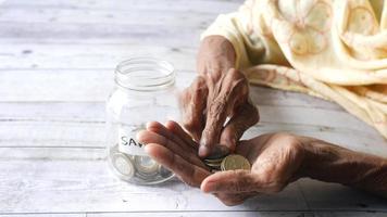 anciana agrega monedas al tarro de ahorros video