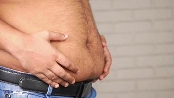 Man touches his belly, overweight, obesity video