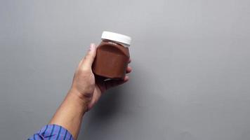 la mano agarra un recipiente de mantequilla de chocolate con avellanas video