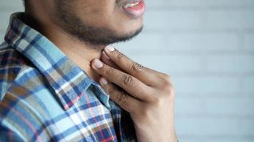 el hombre toca su cuello con dolor, dolor de garganta, problemas de tiroides video