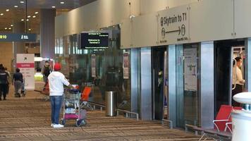 los viajeros esperan el ascensor del skytrain en el aeropuerto video