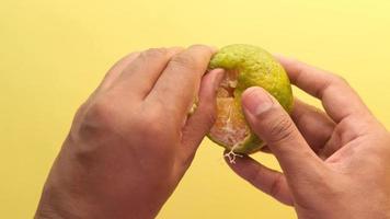 Hands peeling mandarine on a warm background video