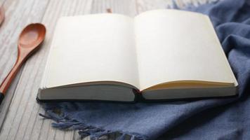 Open pages of a blank notebook in kitchen next to wooden utensils video