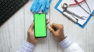 A doctor using a smartphone in the office video