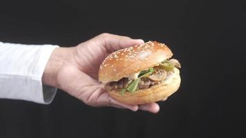 uma mão segura um hambúrguer video