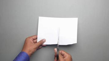 Cutting a piece of papel in half with scissors