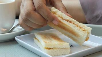 Sándwich tostado sin corteza en plato de cerámica con taza video