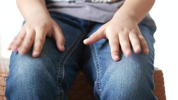 el niño apoya las manos en las piernas golpeando video