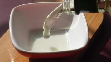 Vegetable oil poured into a bowl, ingredient preparation video