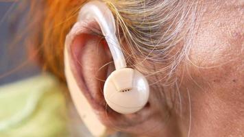 mulher madura usa fones de ouvido, fones de ouvido video