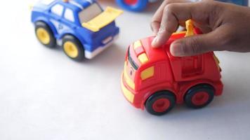 LIttle toy trucks, red and blue, kid is playing video