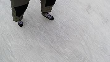 langzaam beweging schot pov persoon met laarzen ijs het schaatsen Aan sneeuw, top naar beneden visie video