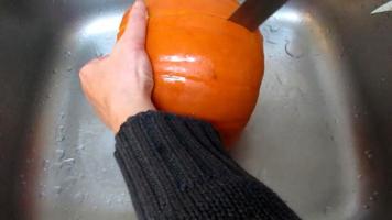 lady cut pumpkin in kitchen sink video