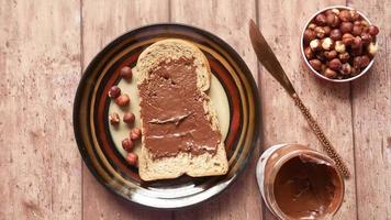 Putting chocolate spread onto slice of bread , top view video