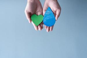 Hands holding green heart and water drop concept of save water save the world. photo