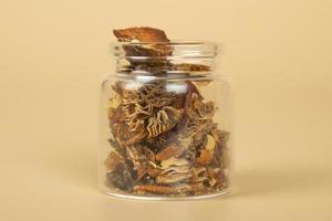 red dried fly agaric in a jar for shamanic rituals and deep trips, natural muscarine mushrooms for microdosing photo