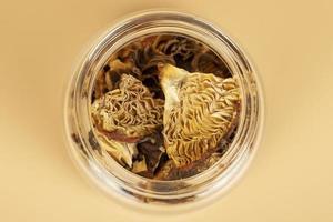 red dried fly agaric in a jar for shamanic rituals and deep trips, natural muscarine mushrooms for microdosing photo