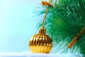 Christmas yellow gold ball on pine and snow. New year card. Copy space photo