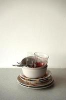 Stack of dirty dishes with food leftovers on the table after meal. Banquet ending concept. Unwashed dishes photo