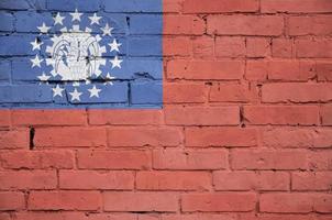 Myanmar flag is painted onto an old brick wall photo