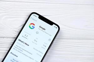 kharkov, ucrania - 5 de marzo de 2021 icono de google y aplicación de la tienda de aplicaciones en la pantalla de visualización del iphone 12 pro en la mesa blanca foto