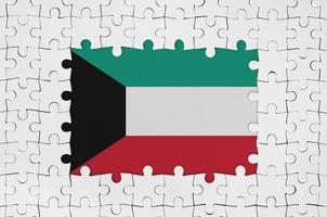 bandera de kuwait en el marco de piezas de un rompecabezas blanco con la parte central faltante foto