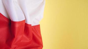 Folded Flag of Poland on Yellow Background photo