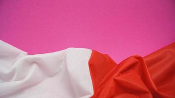 Folded Flag of Poland on Vivid Pink Background photo