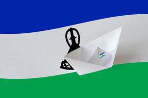 Lesotho flag depicted on paper origami ship closeup. Handmade arts concept photo