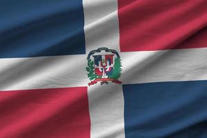 Dominican Republic flag with big folds waving close up under the studio light indoors. The official symbols and colors in banner photo