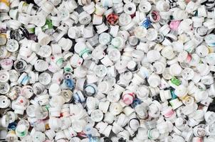A pattern of many used and soiled nozzles from spray cans with aerosol paint. Background texture of the street art of drawing graffiti on the walls photo