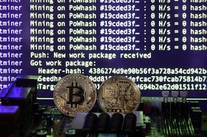 The digital process of cryptocurrency mining by using the GPUs. Bitcoins and video card on a working display and mining screen photo