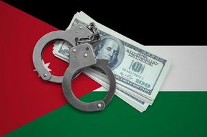 Jordan flag with handcuffs and a bundle of dollars. Currency corruption in the country. Financial crimes photo