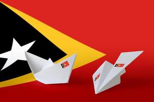 Timor Leste flag depicted on paper origami airplane and boat. Handmade arts concept photo