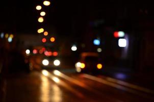 Blurred night scene of traffic on the roadway. Defocused image of cars traveling with luminous headlights. Bokeh Art photo